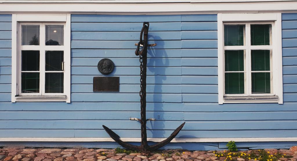 Pakkahuoneen museo. Kuva: Raahen museo. Pakkahuoneen museon seinään nojaa suurikokoinen ankkuri.