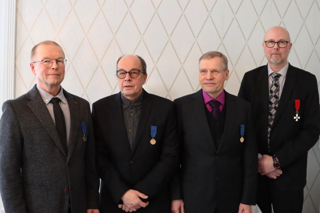 Kuvassa neljä kunniamerkin saanutta henkilöä