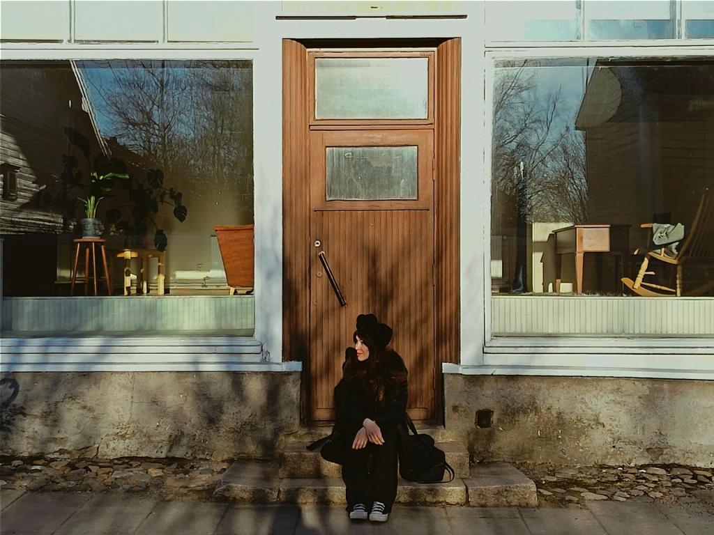 Kuvassa Laura Juntunen istuu vanhan rakennuksen portailla. Kuvaaja Sina Sarpola