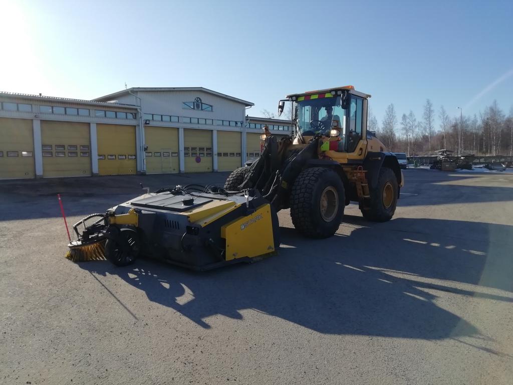Katuja harjataan usean koneyksikön voimin. Pyöräkone harjalaitteen kera.