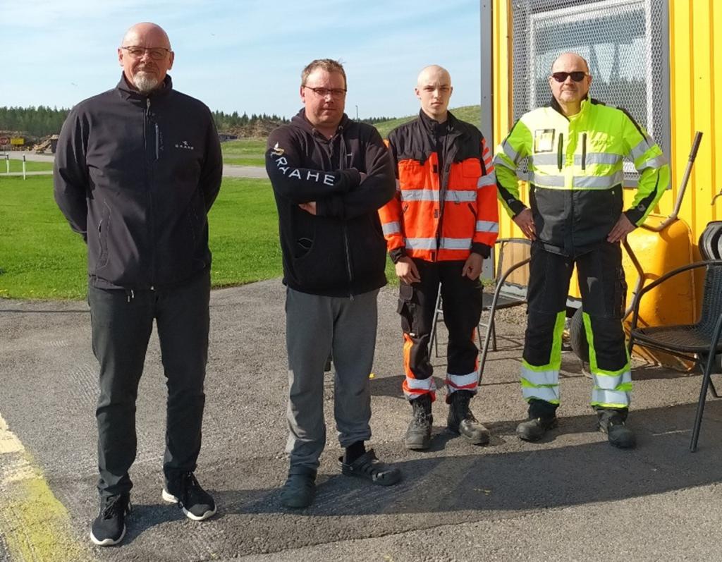 Kuvassa henkilöstöpäällikkö Seppo Sarlin sekä Tommi Ukura, Juuso Saarenpää ja Terho Kukkola Raahen jäteasemalta. Kuva: Piia Suomela. Neljä ihmistä seisoo rivissä jäteaseman toimistorakennuksen ulkopuolella.