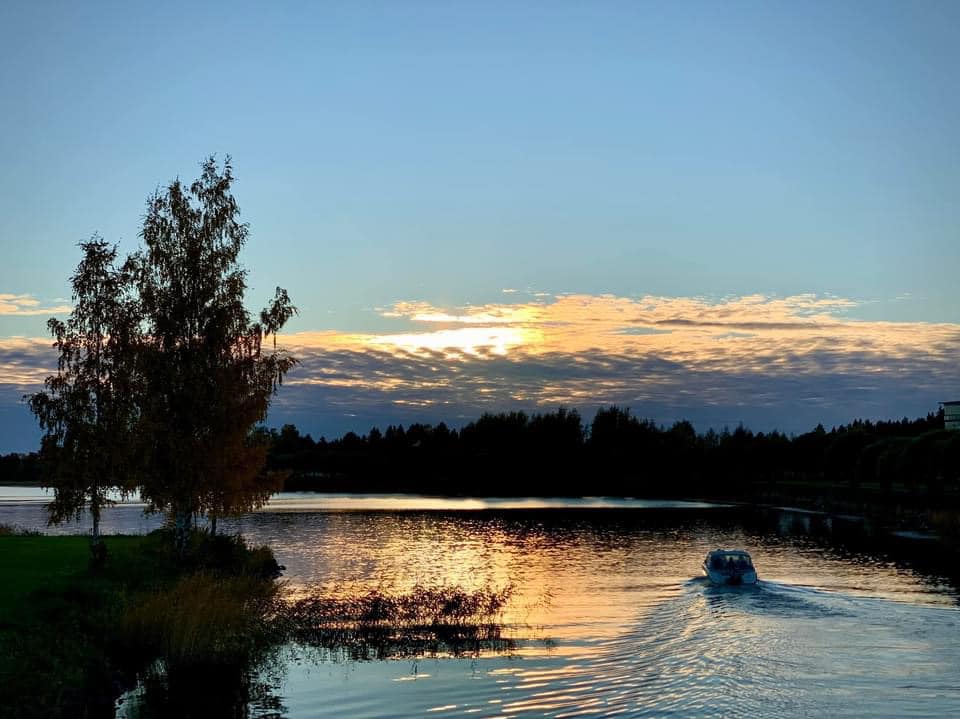 Kuvassa auringonlasku ja vene Pikkulahdella.