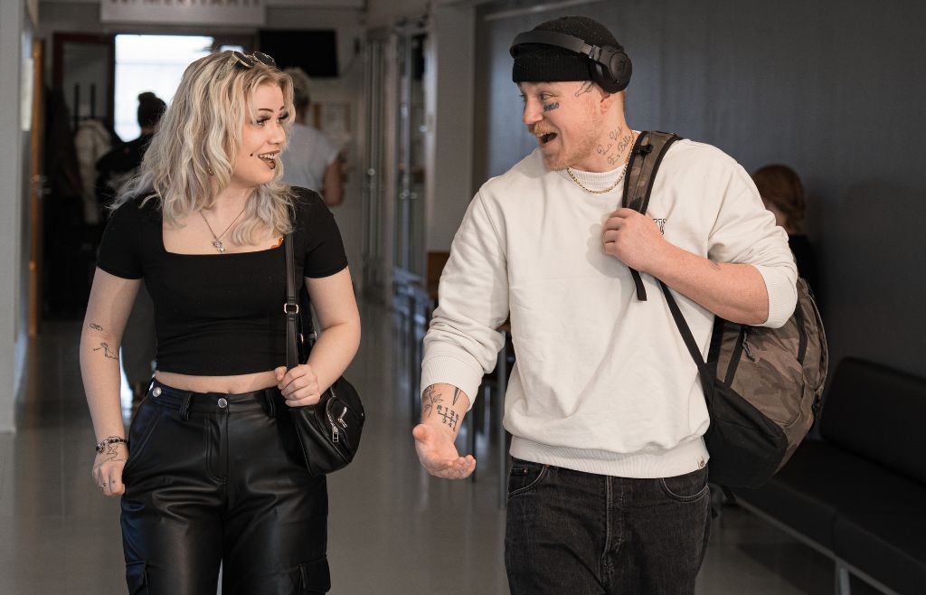 Kaksi henkilöä kävelemässä yhdessä käytävää pitkin.