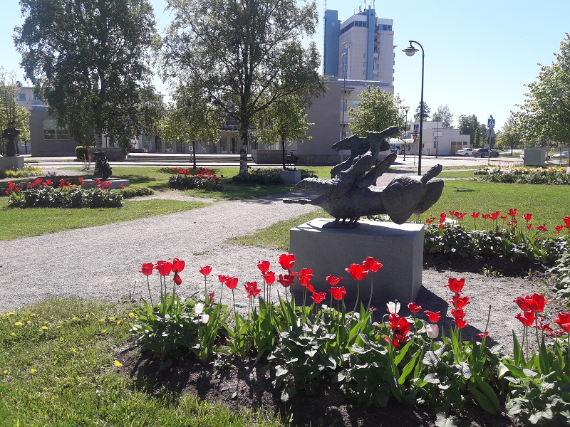 Juvan veistospuistossa kukat kehystävät veistoksia. Kuva Tita Haapajoki. Patsas Juvan veistospuistossa.