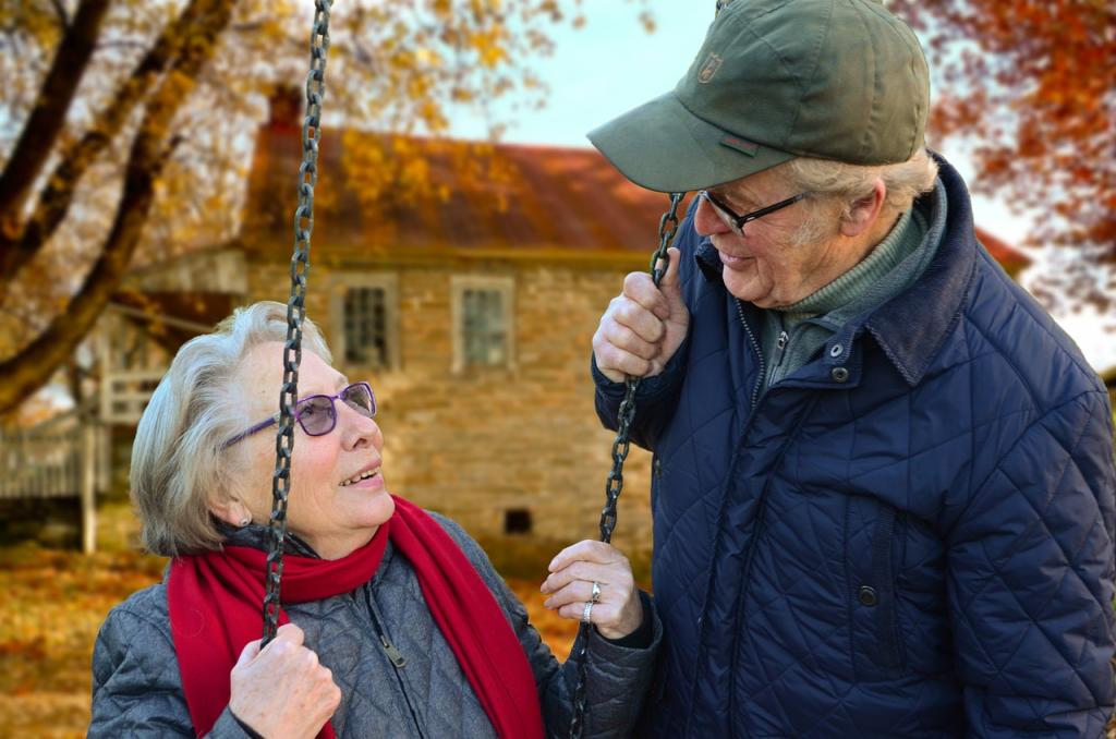 Kuva: Pixabay. Kaksi senioria ulkoilemassa syksyisessä maisemassa; nainen istuu kiikussa ja mies seisoo hänen vierellään.
