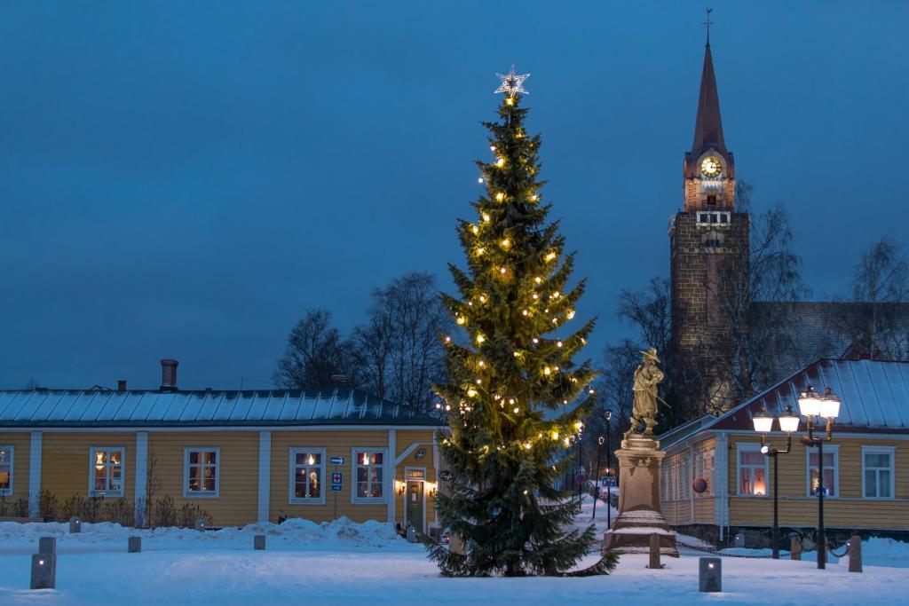 Kuva: Langin Kauppahuone. Sininen hetki Pekkatorilla Wanhassa Raahessa. Etualalla valaistu joulukuusi.