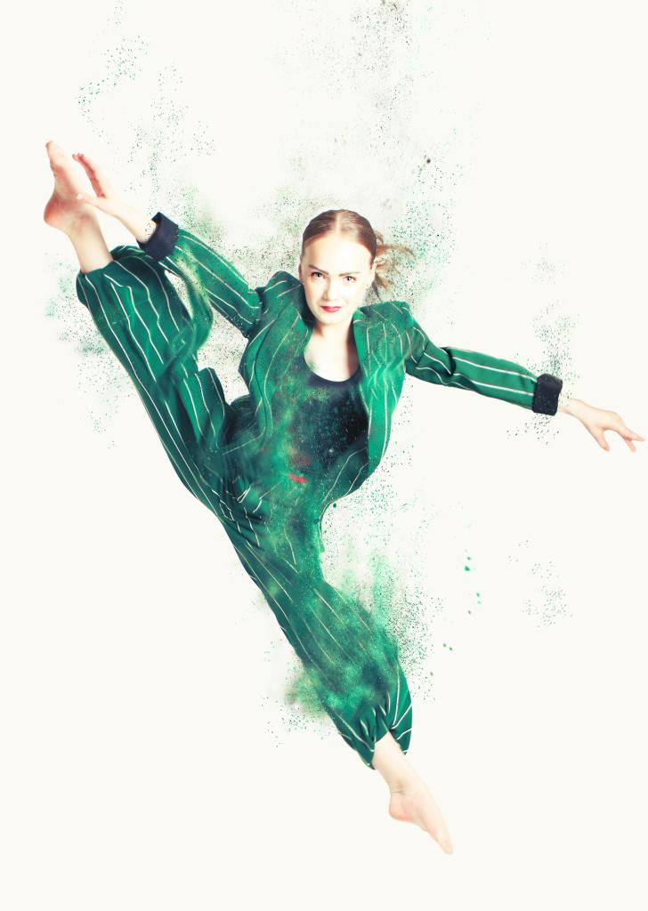 Nuori tanssija vihreässä housupuvussa.