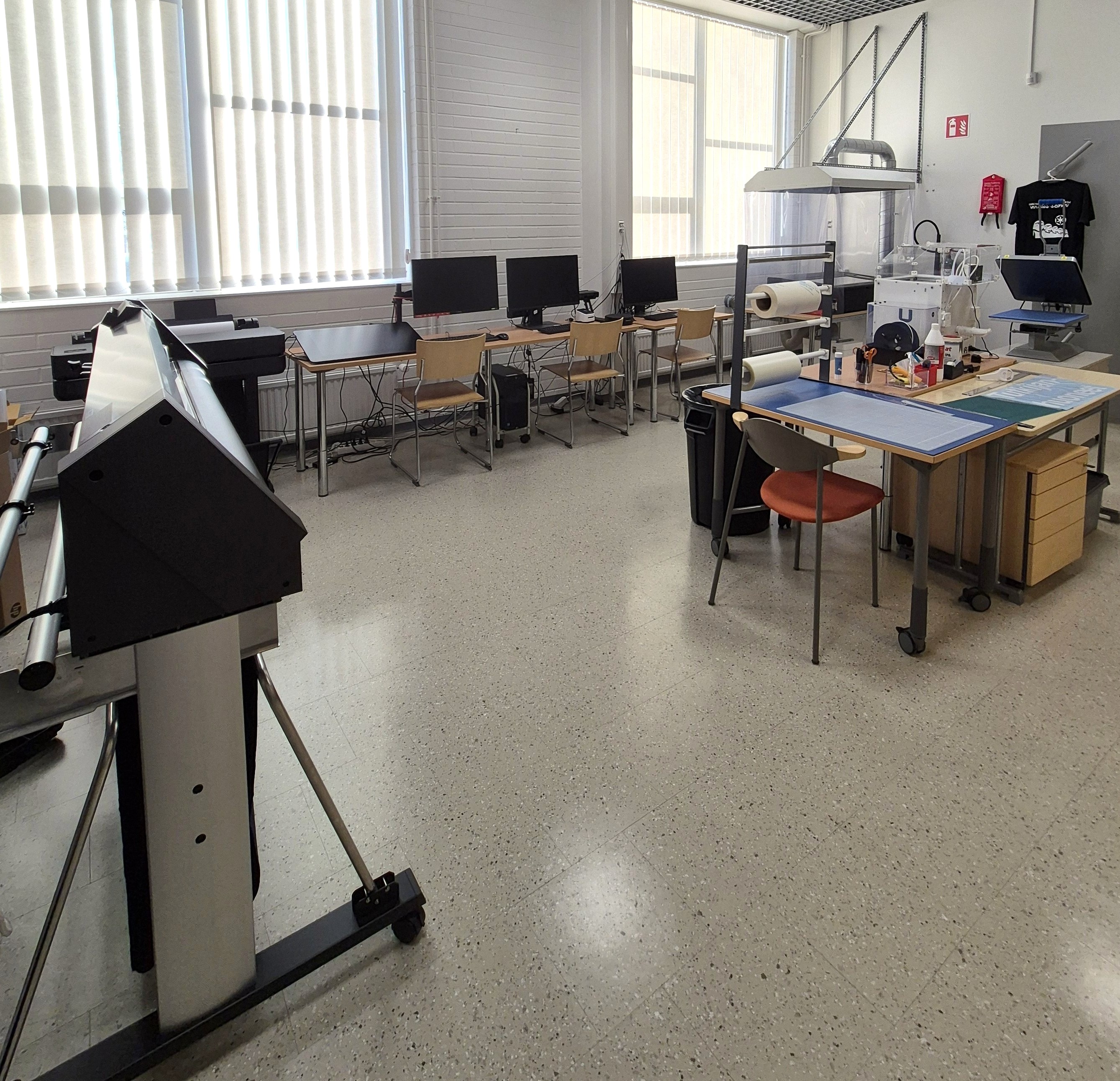 Vinyylileikkuri, suurkuvatulostin ja tietokoneita. 