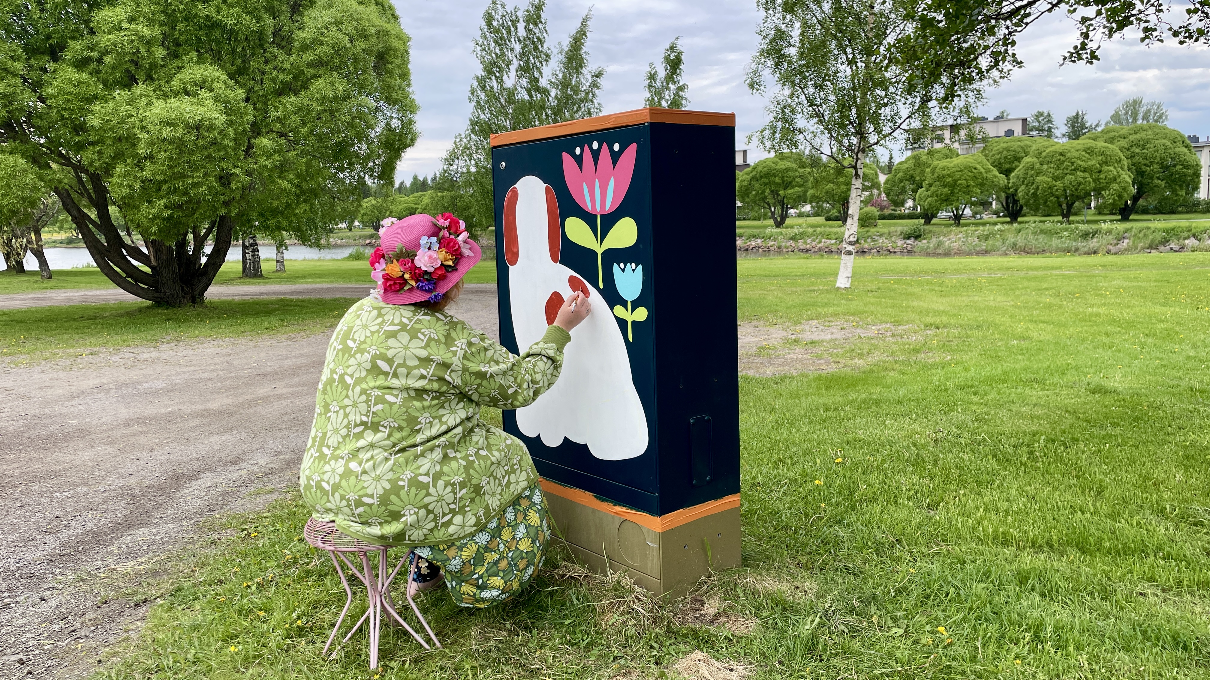 Taiteilija Milka Metsäpolku tekemässä taidetta sähkökaappiin