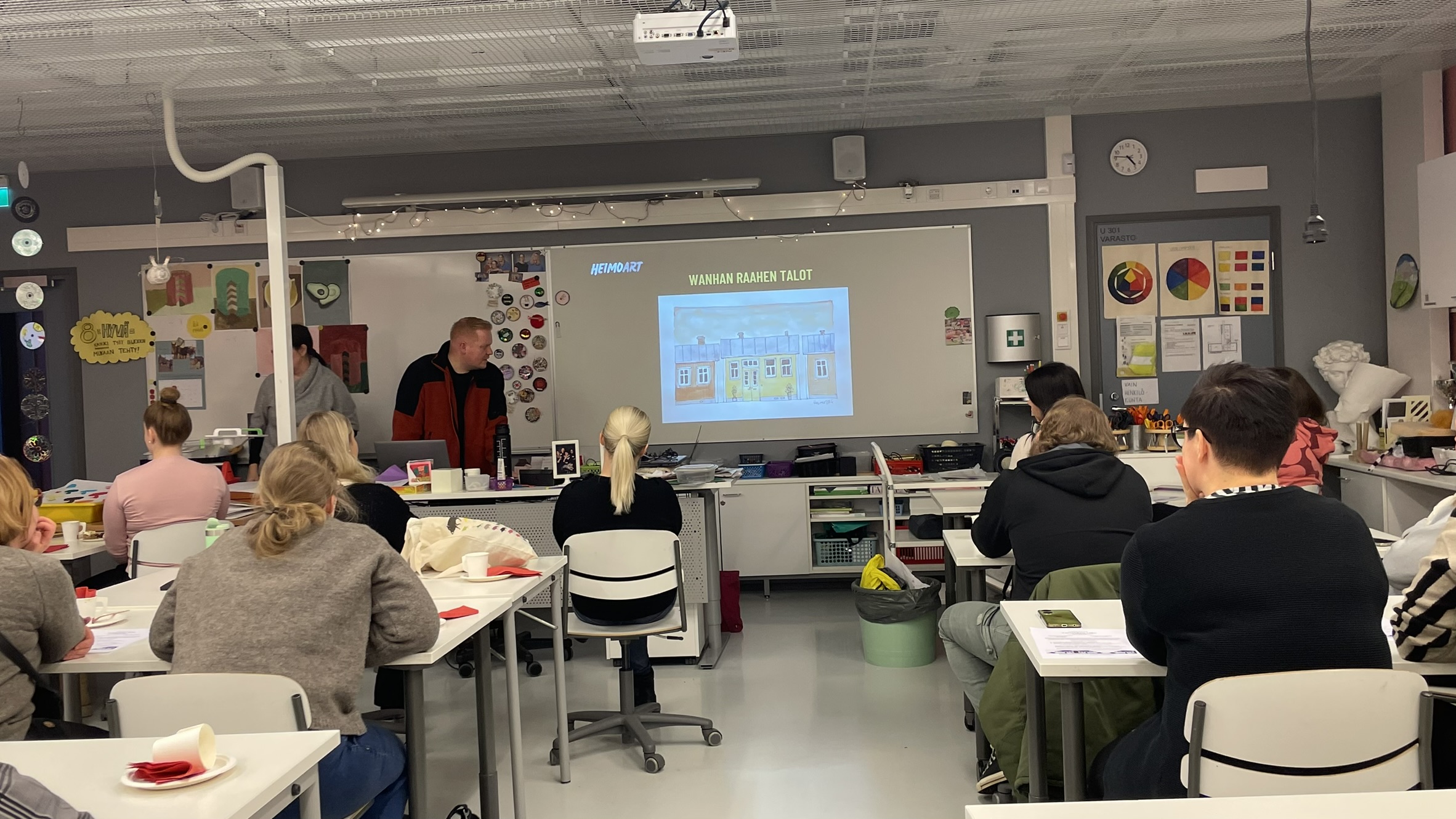 Ryhmä opettajia tarkastelee piirrosta Wanhan Raahen taloista.