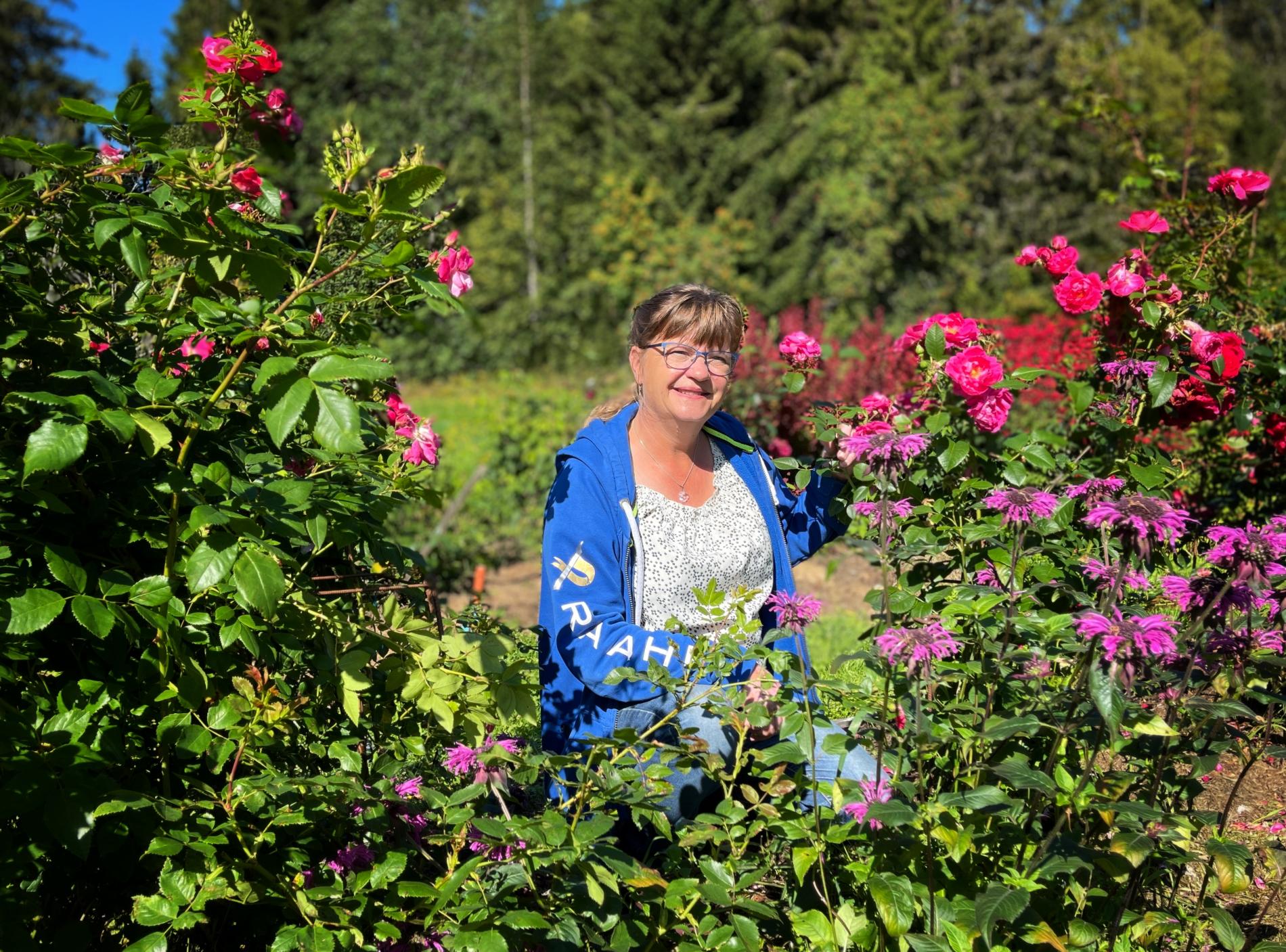 Tita surrounded by roses in her home garden.