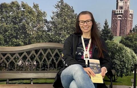 Nainen istuu puiston penkillä Raahen maisemakulisseissa.