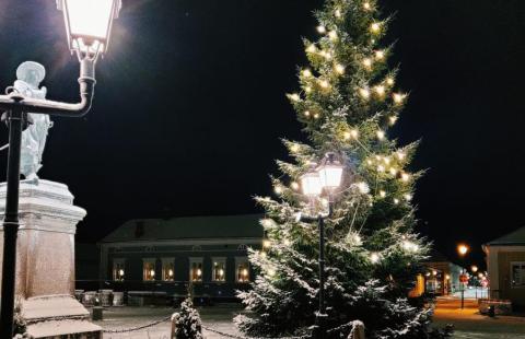 Kuva Pekkatorilta ilta-aikaan. Valaistu kuusi, Pekkapatsas ja taustalla Friemanin talo joulutähdet ikkunoissa.