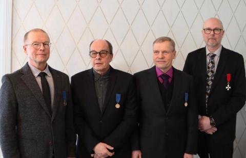 Kuvassa neljä kunniamerkin saanutta henkilöä
