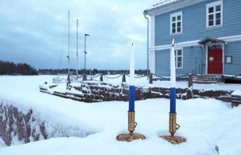 Kuvassa museo ja kaksi sinivalkoista kynttilää.