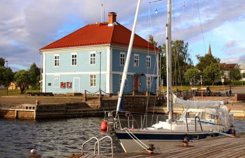 Vaaleansininen, kaksikerroksinen museorakennus meren äärellä.