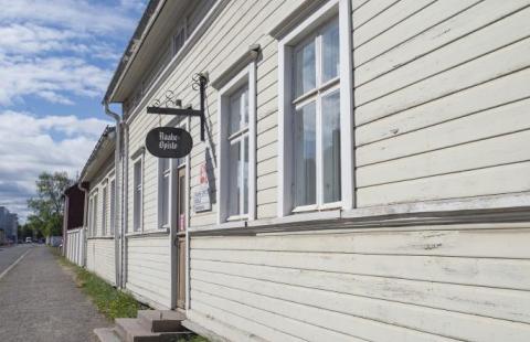 Valkoinen, puuvuorattu rakennus.