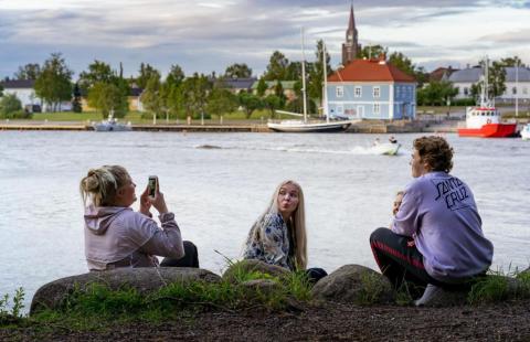 Tre ungdomar roar sig på stranden.