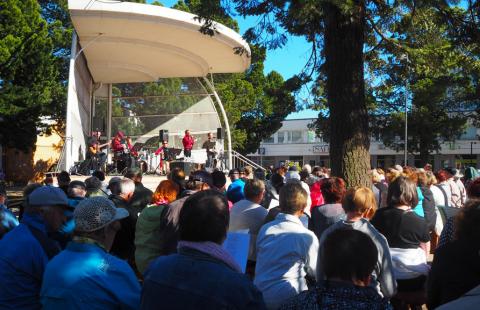 A large crowd sings in the market.