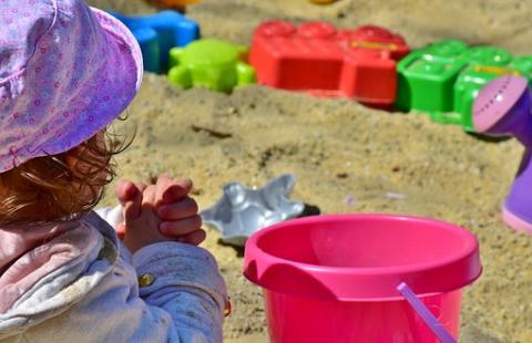The child plays with a sandbox.