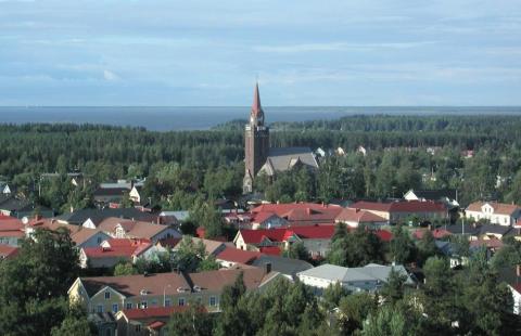 Flygfoton av tak av hus och bakgrunden till kyrktornet.