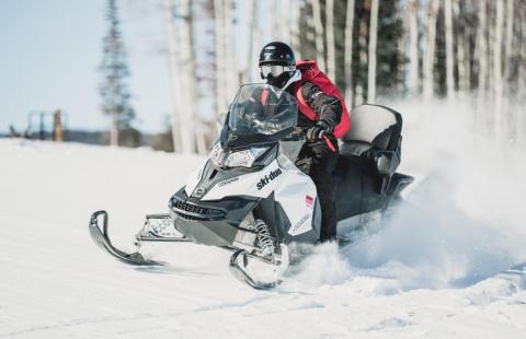 Moottorikelkka etenee vauhdikkaasti lumessa.