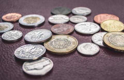 Mynt från olika länder på ett bord.