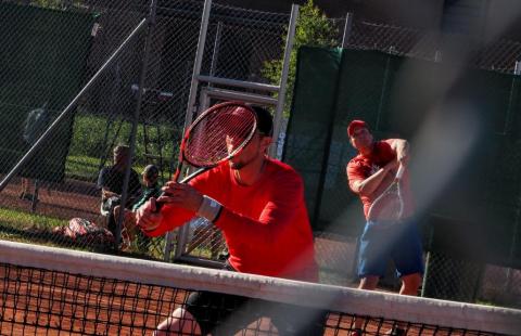 Kaksi henkilöä pelaamassa tennistä.