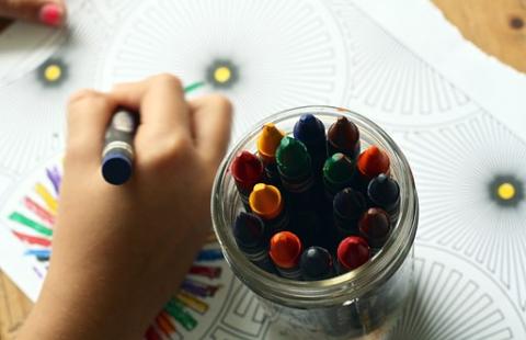 Lapsi piirtää värikynillä.