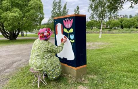 Taiteilija Milka Metsäpolku maalaa sähkökaappia.