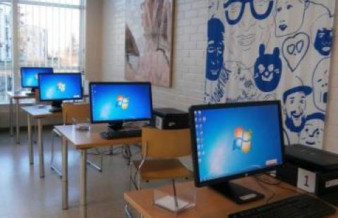 Neljä tietokonetta jonossa omilla pöydillään pääkirjastossa.