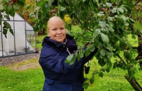 Kuva: Elina Jaakolan kotialbumi. Elina keräämässä syksyn satoa hyötypuutarhassaan.