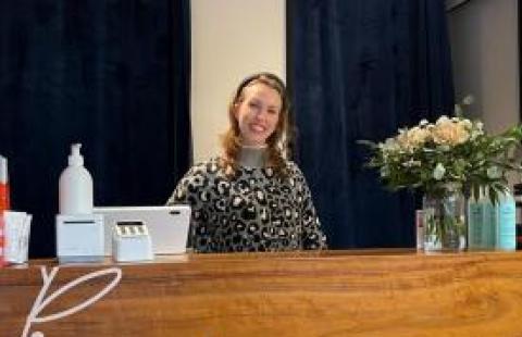Photo: Tarmo Somero. Heidi smiling behind the sales desk in her shop.