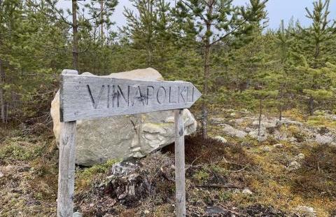 Kuva: Tiina Partanen. Puinen kyltti metsässä, jossa lukee "viinapolku".