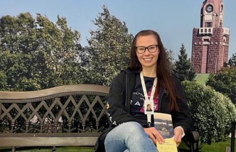 Johanna istuu puiston penkillä Raahen maisemakulisseissa.