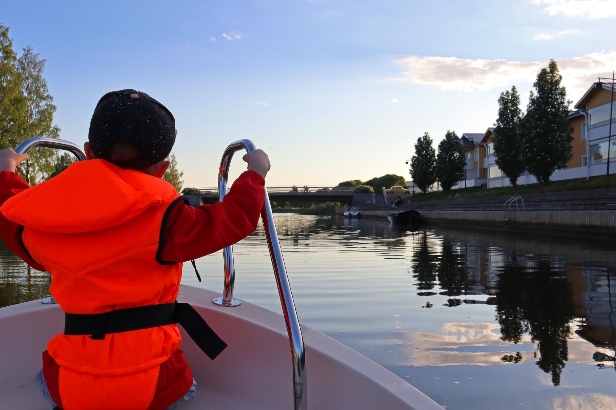 A child in a boat by the Raahe canal shore