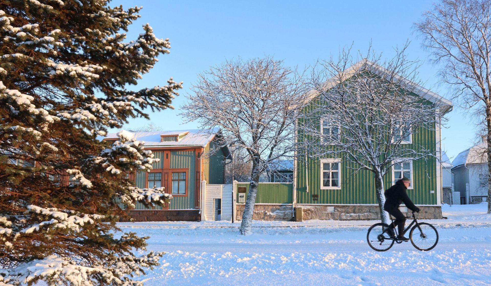 Henkilö pyöräilemässä talvisella Rantakadulla. 