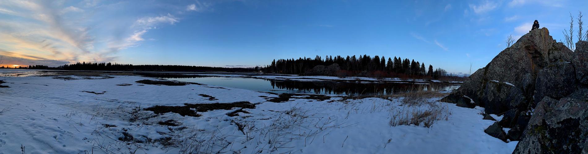 Osittain jäässä oleva meri, auringonlasku ja kallioita.