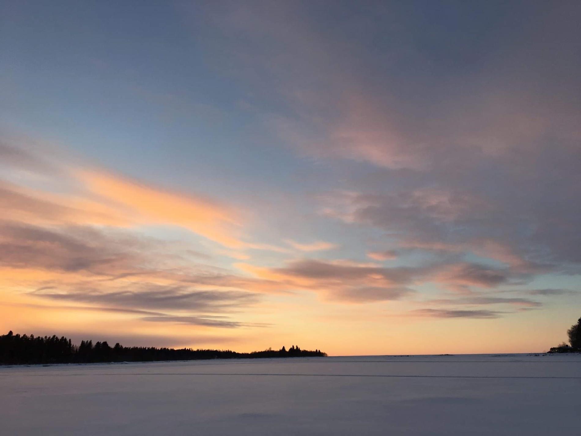 Talvinen näkymä merelle auringonlaskun hetkellä.