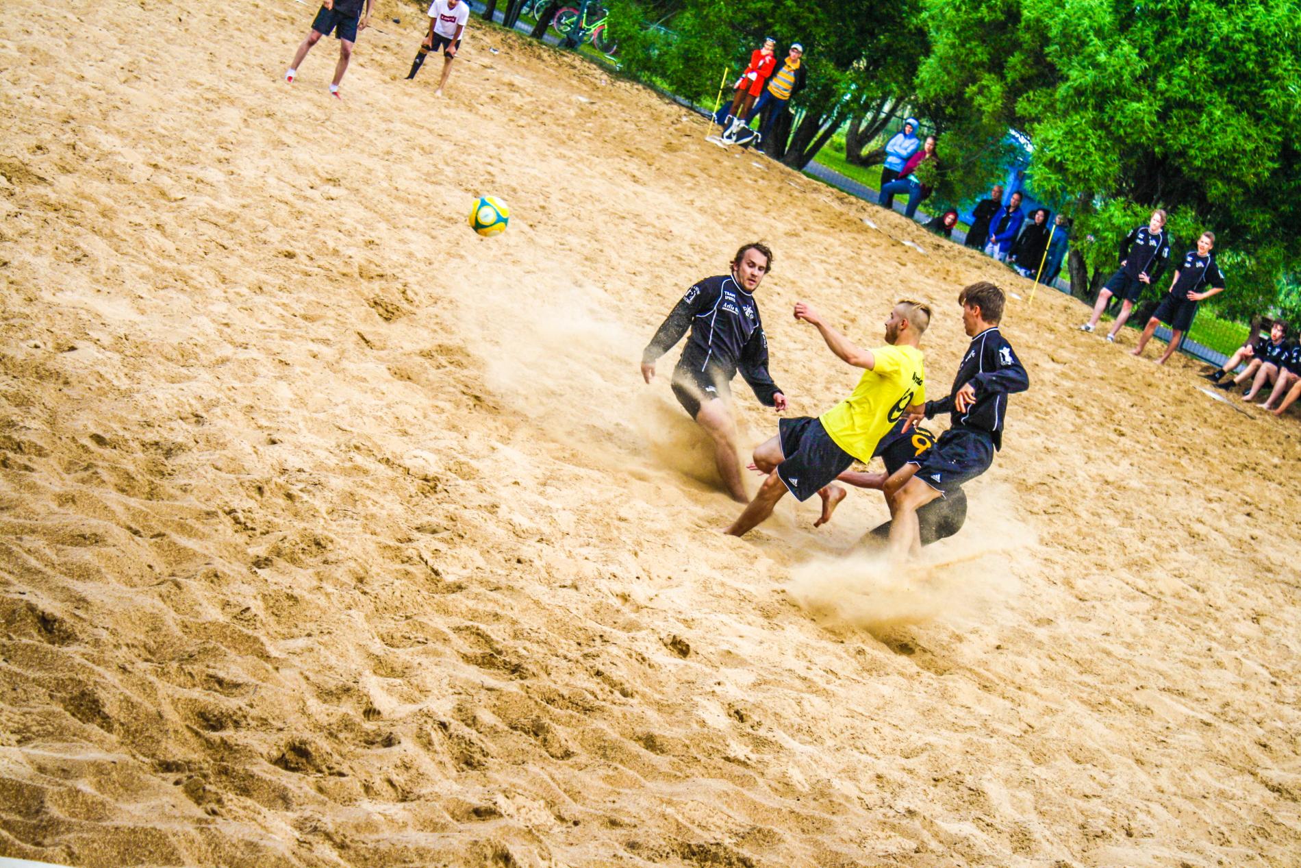 Playing beach football on beach sands.