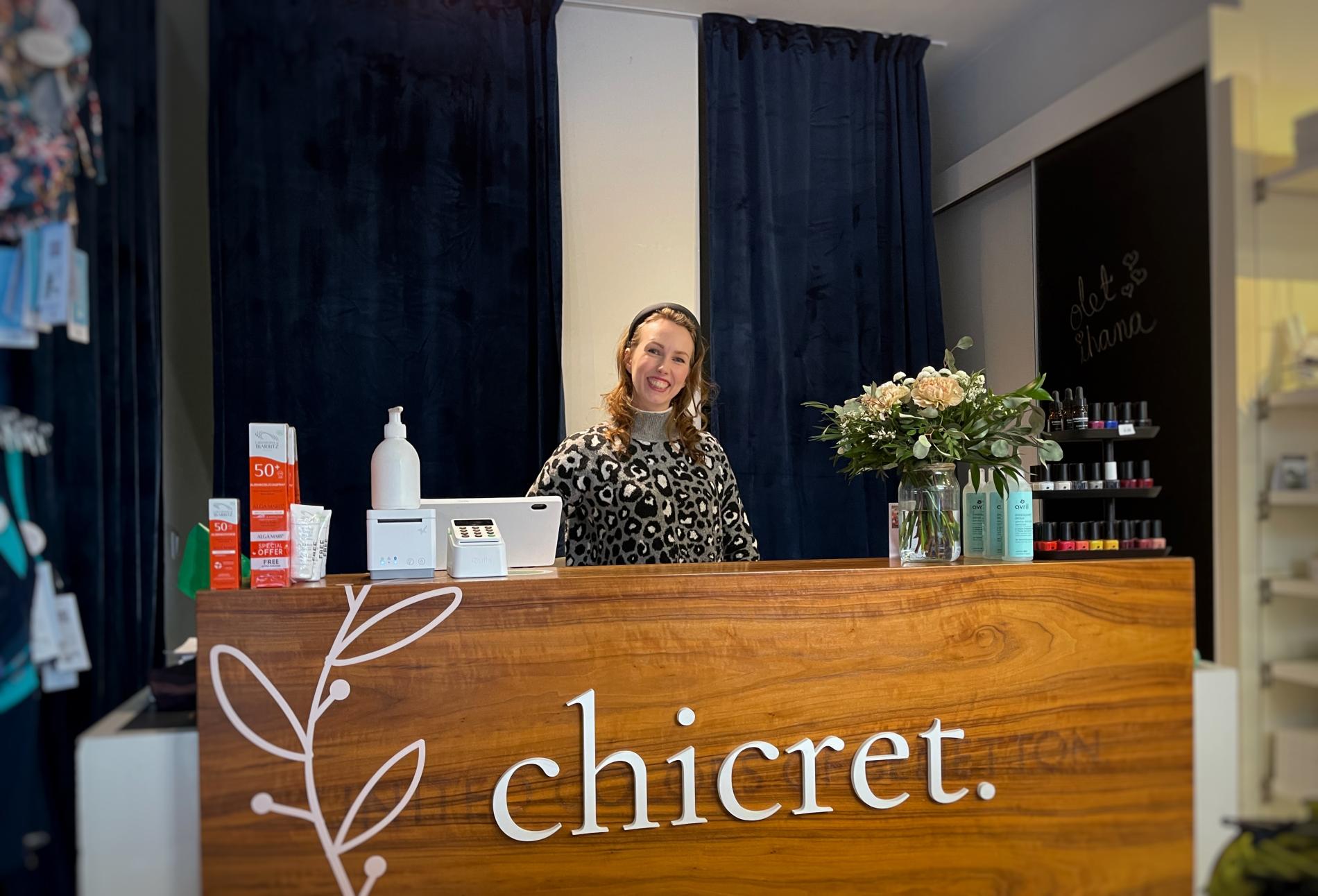 Heidi smiling behind the sales desk in her shop.