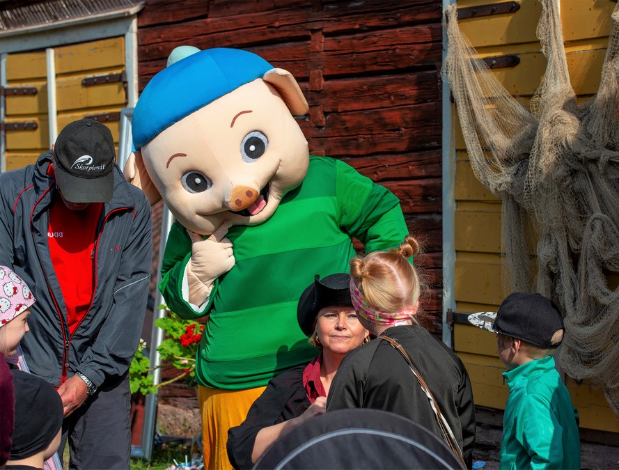 Grismaskoten Possuhahmo lyssnar på barnens berättelser.