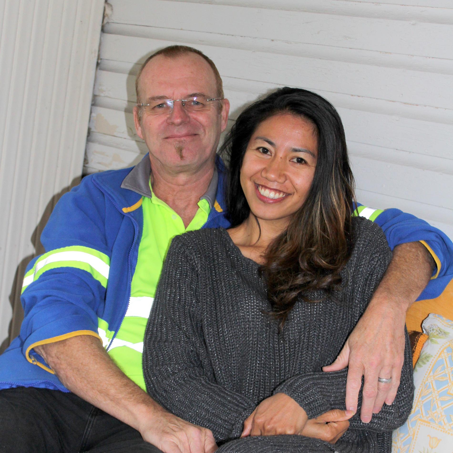 Smiling couple on their home porch.